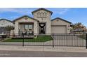 Beautiful single-Gathering home featuring a gray brick exterior, manicured lawn and front gate at 1145 E Gleneagle Dr, Chandler, AZ 85249