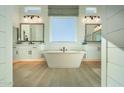 Luxurious bathroom featuring a freestanding tub, dual sinks, modern fixtures, and bright natural lighting at 1180 E Peach Tree Dr, Chandler, AZ 85249