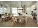 Bright, open-concept kitchen with stainless steel appliances, pendant lighting, a spacious island, and ample cabinet space at 1180 E Peach Tree Dr, Chandler, AZ 85249