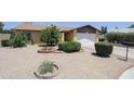 Well-maintained home featuring desert landscaping including gravel, bushes and trees in circular beds at 13012 N 26Th Dr, Phoenix, AZ 85029