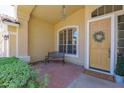Inviting front porch with brick detail, a charming bench, and a 'Come In' welcome mat, offering a cozy entrance at 1420 W Raven Dr, Chandler, AZ 85286