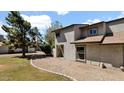 Inviting townhome exterior with gravel landscaping, a secure gate, and mature trees providing shade and curb appeal at 15415 N 2Nd Way, Phoenix, AZ 85022