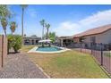 Spacious backyard featuring a refreshing pool, covered patio, and tall palm trees at 1670 E Whitten St, Chandler, AZ 85225
