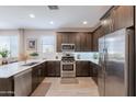 Modern kitchen with stainless steel appliances, quartz countertops, and wood flooring at 17219 W La Luz Rd, Surprise, AZ 85387
