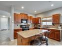 This eat-in kitchen offers an island with bar stool seating, rich wood cabinets, and neutral countertops at 17562 W Agave Ct, Goodyear, AZ 85338