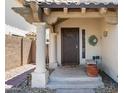 Inviting front entrance with a decorative brown door, white columns, and drought resistant landscaping at 18031 N 12Th Pl, Phoenix, AZ 85022