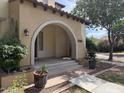 Charming home featuring an arched entryway with lush landscaping and a red brick walkway at 21183 W Main St, Buckeye, AZ 85396