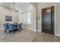 Bright dining room featuring wood-look tile flooring, a modern ceiling fan, and large windows at 22255 E Quintero Rd, Queen Creek, AZ 85142