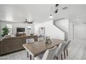 Bright dining area with a wooden table, gray chairs, and an open view of the living room at 22341 N 100Th Ln, Peoria, AZ 85383