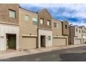 View of modern townhome exteriors with tan and brown color scheme and attached garages at 2256 W Laurie Ln, Phoenix, AZ 85021