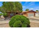 Single-story brick home featuring an attached two-car garage and mature landscaping at 2264 S Don Carlos --, Mesa, AZ 85202