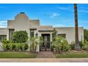 Stunning home featuring an ornamental gate, lush landscaping, and a meticulously manicured lawn at 3109 E Sierra Madre Way, Phoenix, AZ 85016