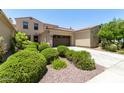 Charming home exterior with a two-car garage, meticulous landscaping, and a well-maintained lawn at 3554 N Hooper St, Buckeye, AZ 85396