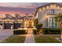 Illuminated front exterior with well-manicured landscaping, a brick walkway, and dormer windows at dusk at 3684 E Boot Track Trl, Gilbert, AZ 85296