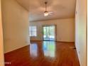 Open living room featuring wood flooring, a ceiling fan, and sliding doors to the backyard at 3932 E Tierra Buena E Ln, Phoenix, AZ 85032