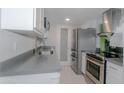 Galley kitchen featuring stainless steel appliances, white cabinets, and gray countertops at 4255 N 68Th Dr, Phoenix, AZ 85033
