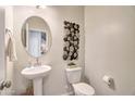 Charming powder room features a pedestal sink, round mirror, and modern wall art at 4999 E Umber Rd, San Tan Valley, AZ 85143