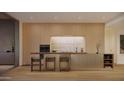 Modern kitchen featuring sleek wood cabinetry, stainless steel appliances, and a stylish breakfast bar with seating at 5050 N Camelback Ridge Dr # 2101, Scottsdale, AZ 85251