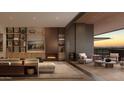 Open living room with sleek built-ins, fireplace, and seamless access to a private terrace and desert sunset view at 5050 N Camelback Ridge Dr # 2101, Scottsdale, AZ 85251