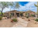 Charming home with desert landscaping, a stone pathway, and native cacti in the front yard at 5712 E Blue Sky Dr, Scottsdale, AZ 85266