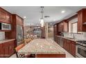 Kitchen island featuring granite countertops, seating, and stainless steel appliances at 6532 E Aster Dr, Scottsdale, AZ 85254
