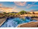 Beautiful pool and spa with mountain views, lush desert vegetation and colorful sunset at 6551 E Flat Iron Loop, Gold Canyon, AZ 85118