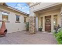 Inviting entryway with a stone pillar, wooden door and string lights at 6706 S Jacqueline Way, Gilbert, AZ 85298