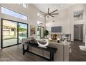 Bright living room featuring high ceilings, a modern ceiling fan, and patio access to the pool at 7439 E Beryl Ave, Scottsdale, AZ 85258