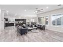 Bright living room with an open floor plan, marble floors, and dark furniture at 11957 W Daley Ln, Sun City, AZ 85373