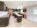 Modern kitchen with custom cabinets, kitchen island, and tiled floors at 12230 N 47Th Dr, Glendale, AZ 85304