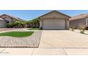 Charming single-story home featuring a beige exterior, a two car garage, and meticulous landscaping at 12425 W Willow Ave Ave, El Mirage, AZ 85335