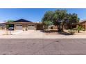 Single-story home with brick accents, a two-car garage, mature tree, and landscaping at 13041 N 51St Dr, Glendale, AZ 85304
