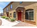 Charming home entrance showcases a red door, stone accents, and manicured landscaping at 1350 S Greenfield Rd # 1005, Mesa, AZ 85206