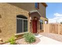 Inviting home entrance features a red door, complemented by stone accents, and neatly trimmed shrubs at 1350 S Greenfield Rd # 1005, Mesa, AZ 85206