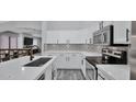 Modern kitchen featuring white cabinets, stainless steel appliances and patterned backsplash at 14952 W Maui Ln, Surprise, AZ 85379