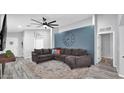 Cozy living room featuring a sectional sofa, ceiling fan and accent wall at 14952 W Maui Ln, Surprise, AZ 85379