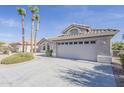Lovely single-story home with a tiled roof, complemented by a concrete driveway and palm trees at 15411 W Amelia Dr, Goodyear, AZ 85395