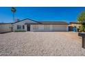 Inviting single-story home showcasing light gravel landscaping, a new roof, black trim, and a spacious concrete driveway at 1720 W Behrend Dr, Phoenix, AZ 85027
