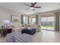 Bright living room with stylish seating, modern decor, a ceiling fan, and a view of the backyard at 18161 W Cielo Grande Ave, Surprise, AZ 85387