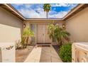 Inviting entryway with a pathway leading to double doors, complemented by palm trees at 1887 E La Donna Dr, Tempe, AZ 85283