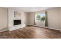 Spacious living room showcasing wood floors, a fireplace, and a bright window at 1887 E La Donna Dr, Tempe, AZ 85283