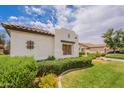 Landscaped front yard with a grassy lawn and desert plants surrounding a beautiful stucco home at 19347 E Thornton Rd, Queen Creek, AZ 85142