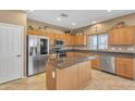 Bright kitchen with stainless steel appliances, wood cabinetry, and granite countertops with island at 209 N 237Th Ave, Buckeye, AZ 85396