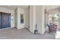 Covered porch with neutral tones, space for seating, and a secure front entrance at 209 N 237Th Ave, Buckeye, AZ 85396