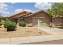 Beige home showing a two-car garage and a desert-style yard in a residential neighborhood at 3248 W Sunshine Butte Dr, San Tan Valley, AZ 85144