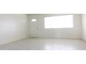 Empty room with light tile flooring and large windows letting in sunlight at 3556 W Augusta Ave, Phoenix, AZ 85051