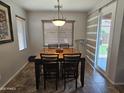Cozy dining area featuring a wooden table with chairs, complemented by a modern light fixture, perfect for Gathering meals at 36119 W Catalan St, Maricopa, AZ 85138