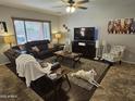 Comfortable living room featuring two sofas, entertainment center and large windows that fill the room with natural light at 36119 W Catalan St, Maricopa, AZ 85138