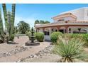 Close-up of a desert-landscaped home featuring a decorative water fountain and manicured greenery at 5345 E Mclellan Rd # 123, Mesa, AZ 85205