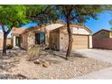 Charming single-story house with desert landscaping, mature trees, and a cozy feel at 5675 S 239Th Ln, Buckeye, AZ 85326